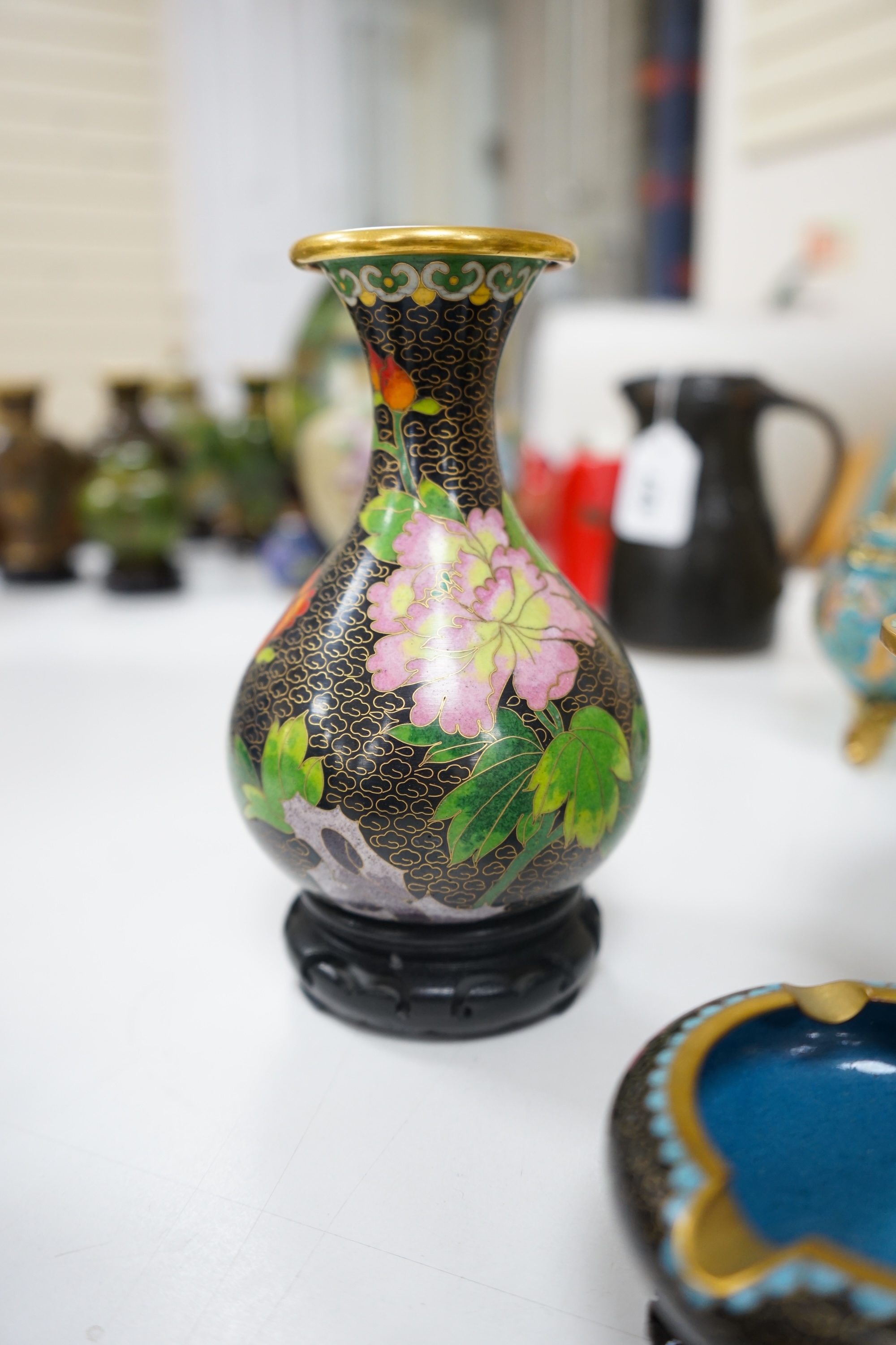 A collection of Chinese cloisonné enamel vessels, some with stands, all worked on a black background in floral designs, plate 26cm diameter. Condition - good